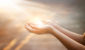 Woman hands praying for blessing from god on sunset background